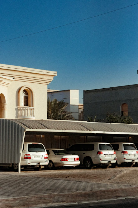 A professional business owner reviewing insurance documents next to a fleet of commercial vehicles under a clear blue sky