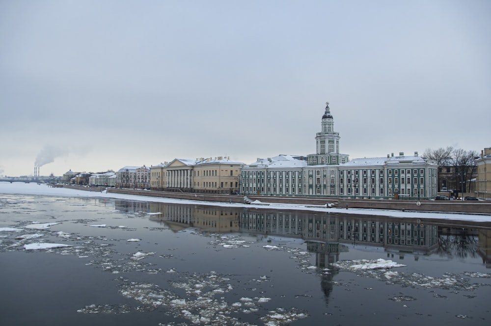 a large building with a clock tower next to a body of water