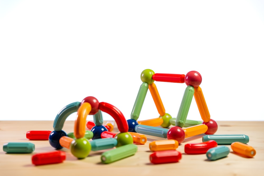 a pile of colorful wooden toys sitting on top of a wooden table