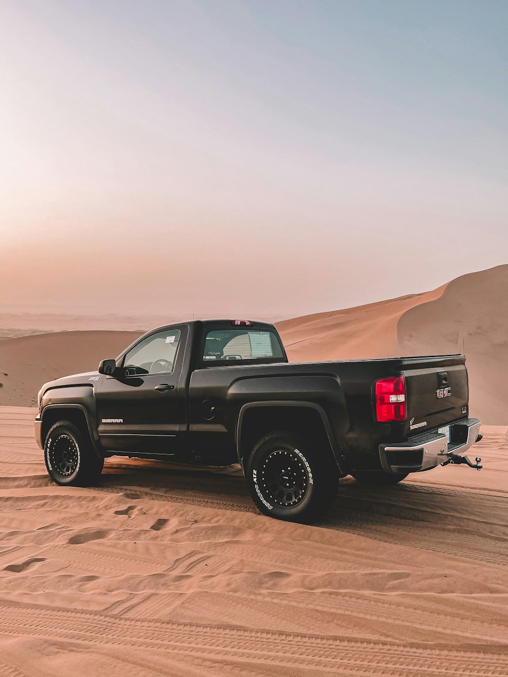 a black truck is parked in the desert