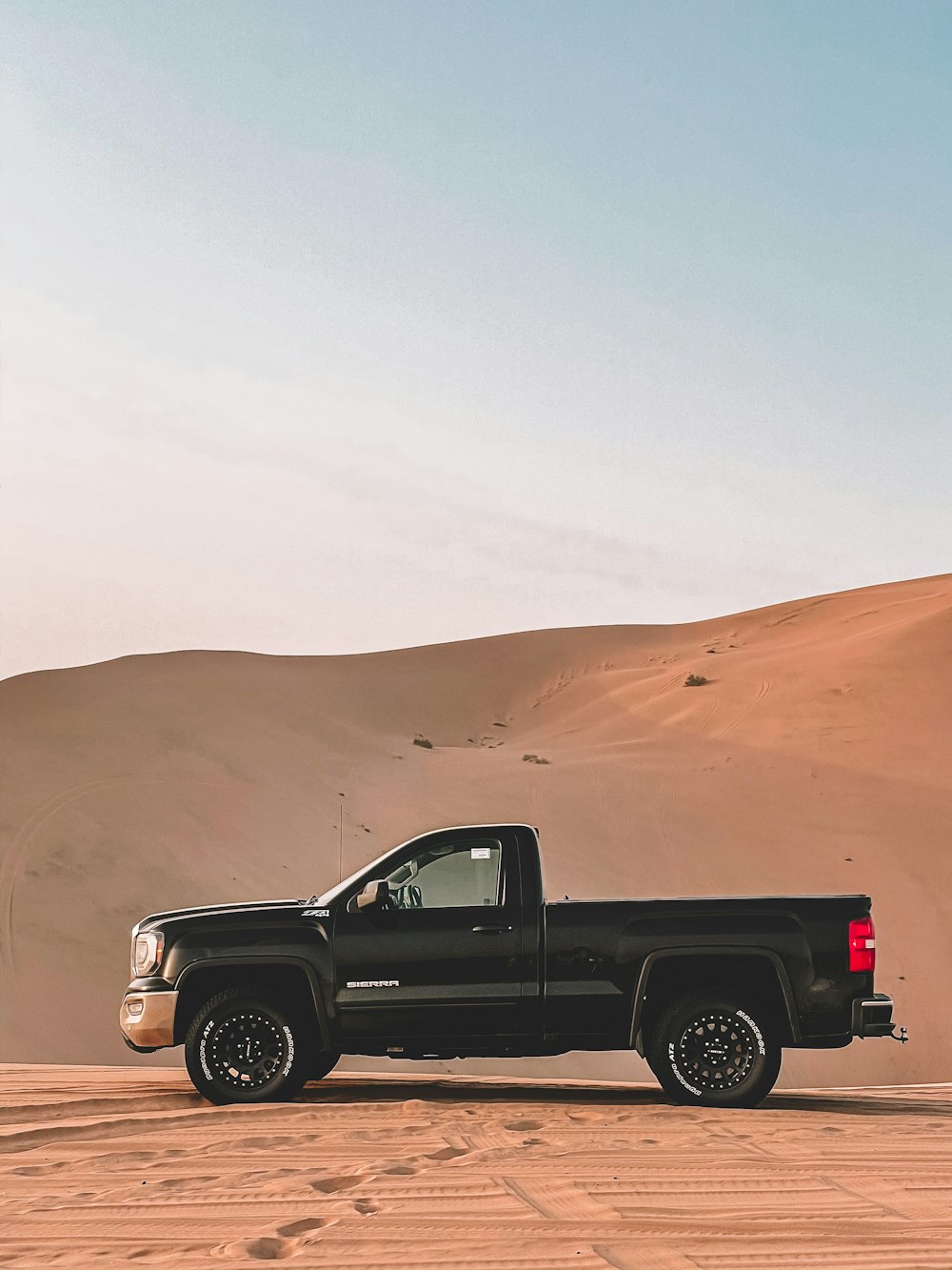 a black truck is parked in the desert