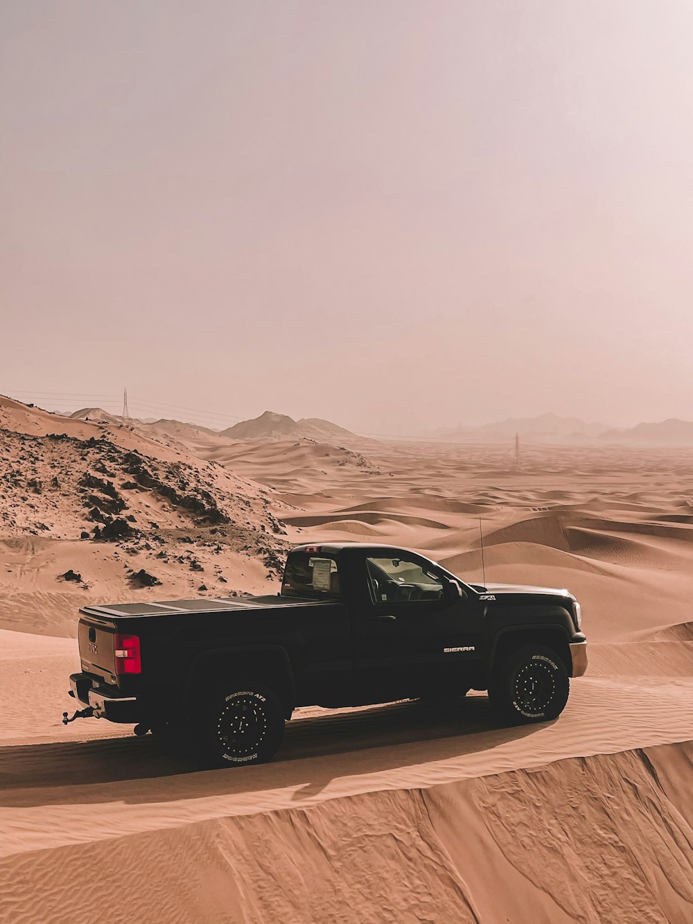 a black truck is driving through the desert