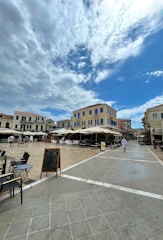 An inviting scene from a European street café with cobblestone roads and travelers enjoying a sunny afternoon.