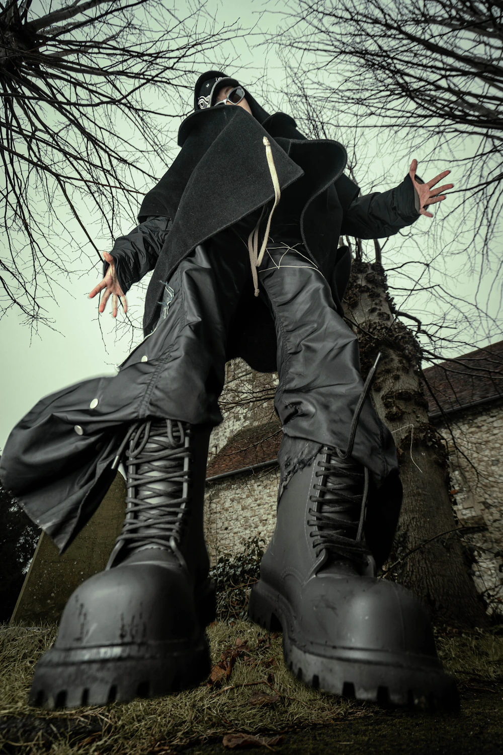 Homem usando casaco preto e botas em editorial de moda