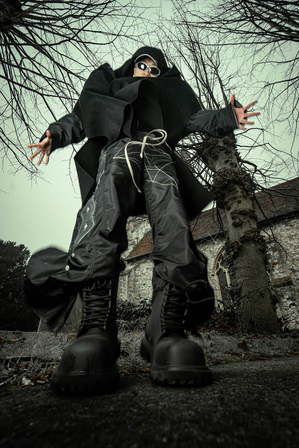 a person in a black outfit and black boots