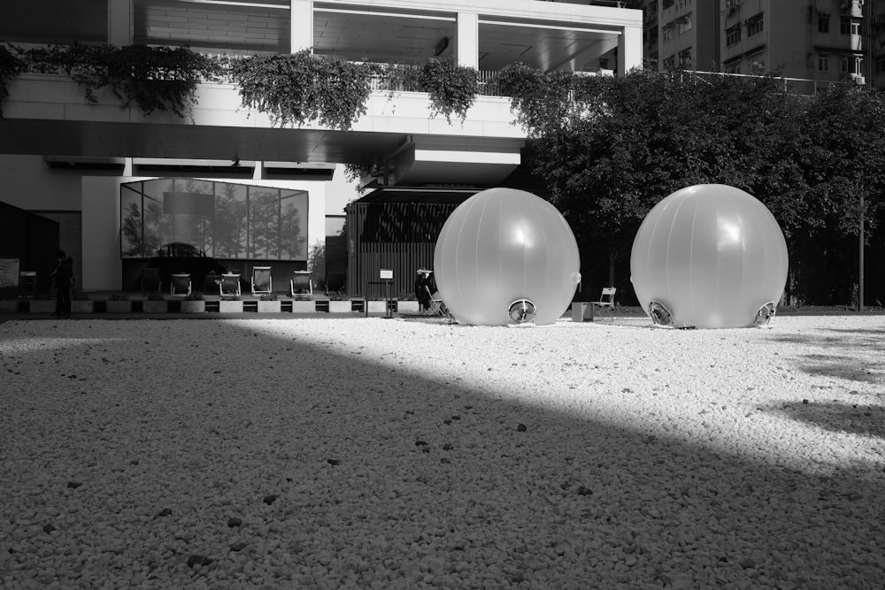 a couple of large white balls sitting in the middle of a street