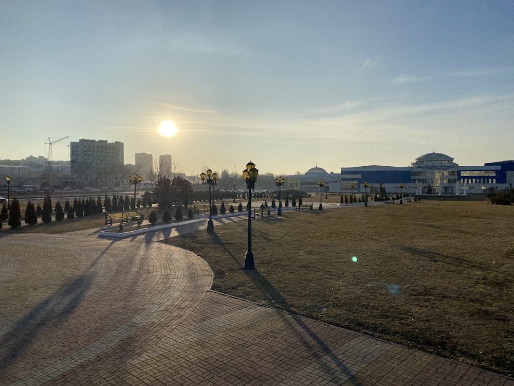 the sun is setting over a city park