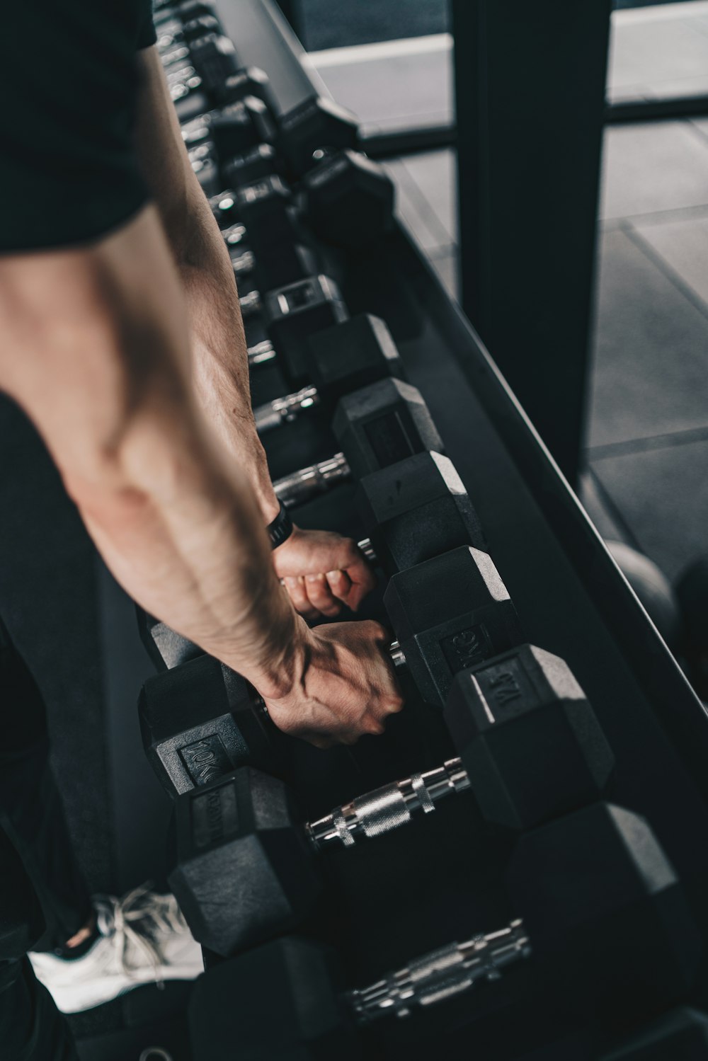 a man is doing exercises with dumbs in a gym