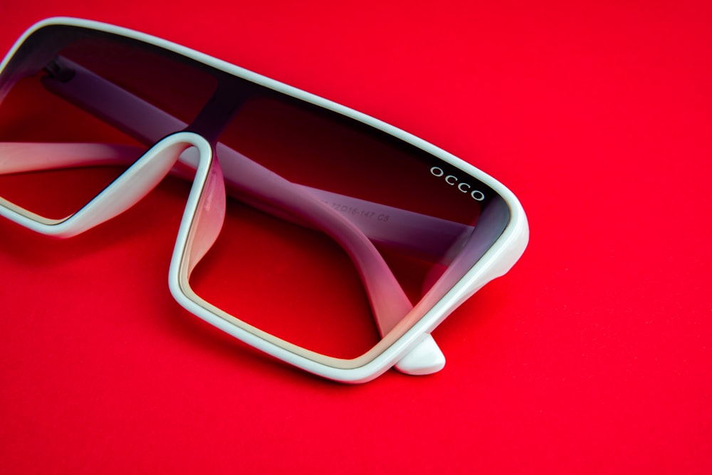 a pair of sunglasses laying on a red surface