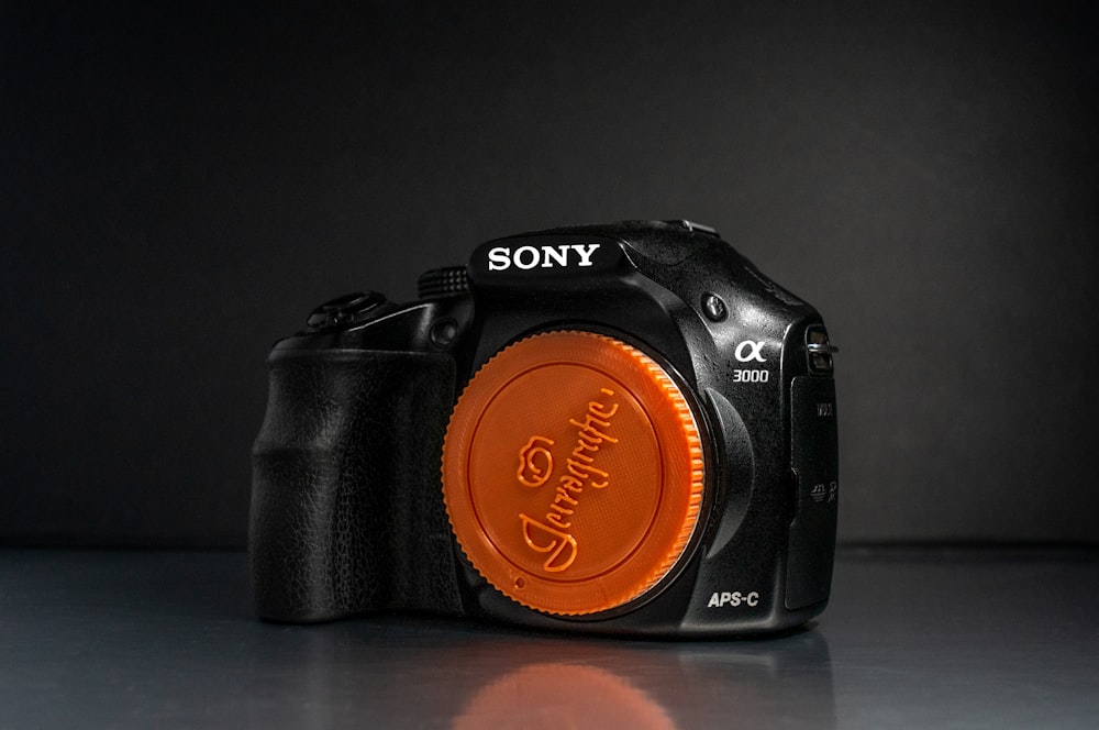 a black and orange camera on a table