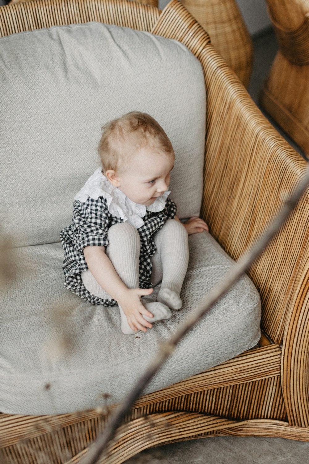 a baby sitting in a wicker chair