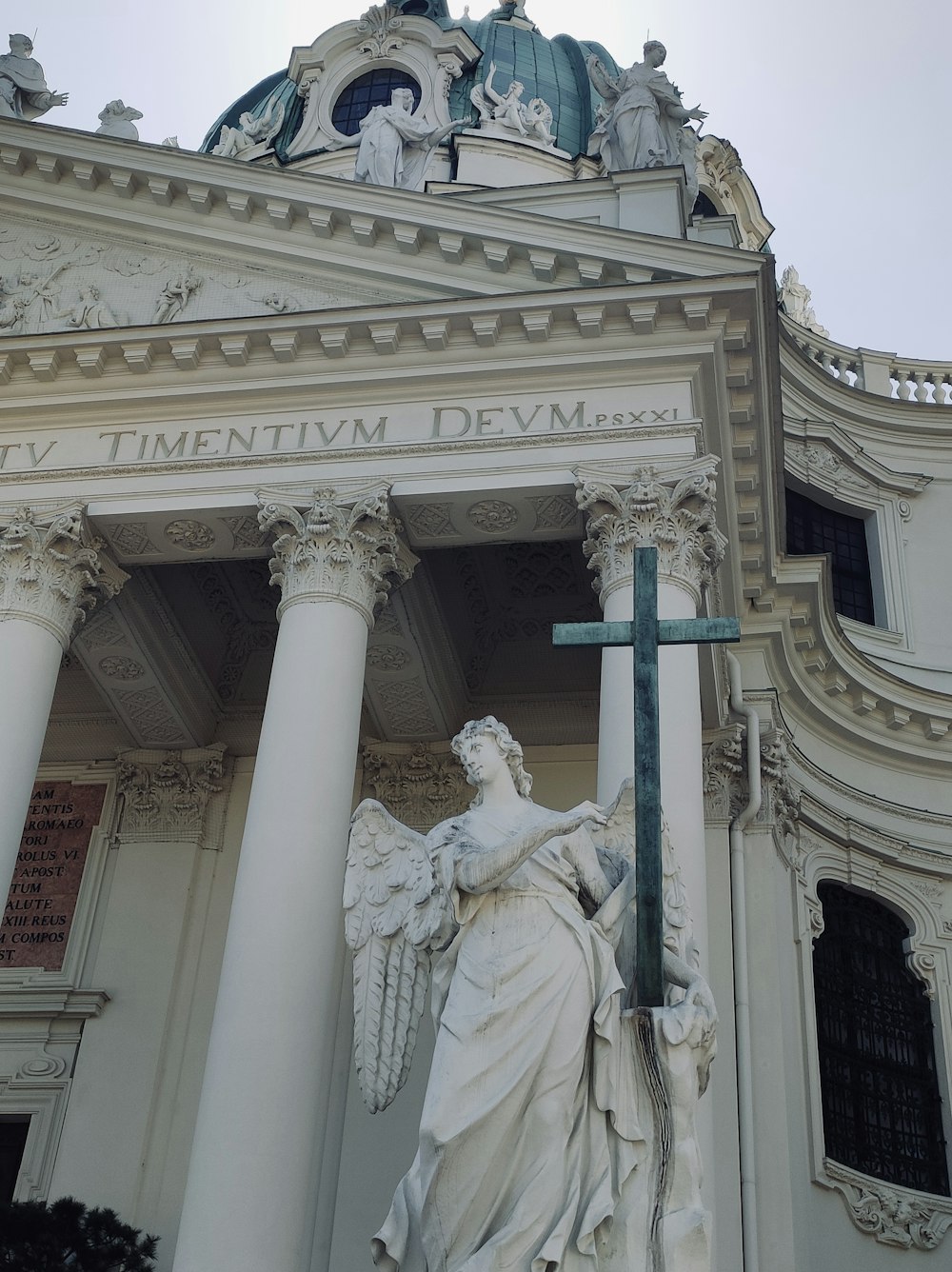a statue of a woman holding a cross in front of a building