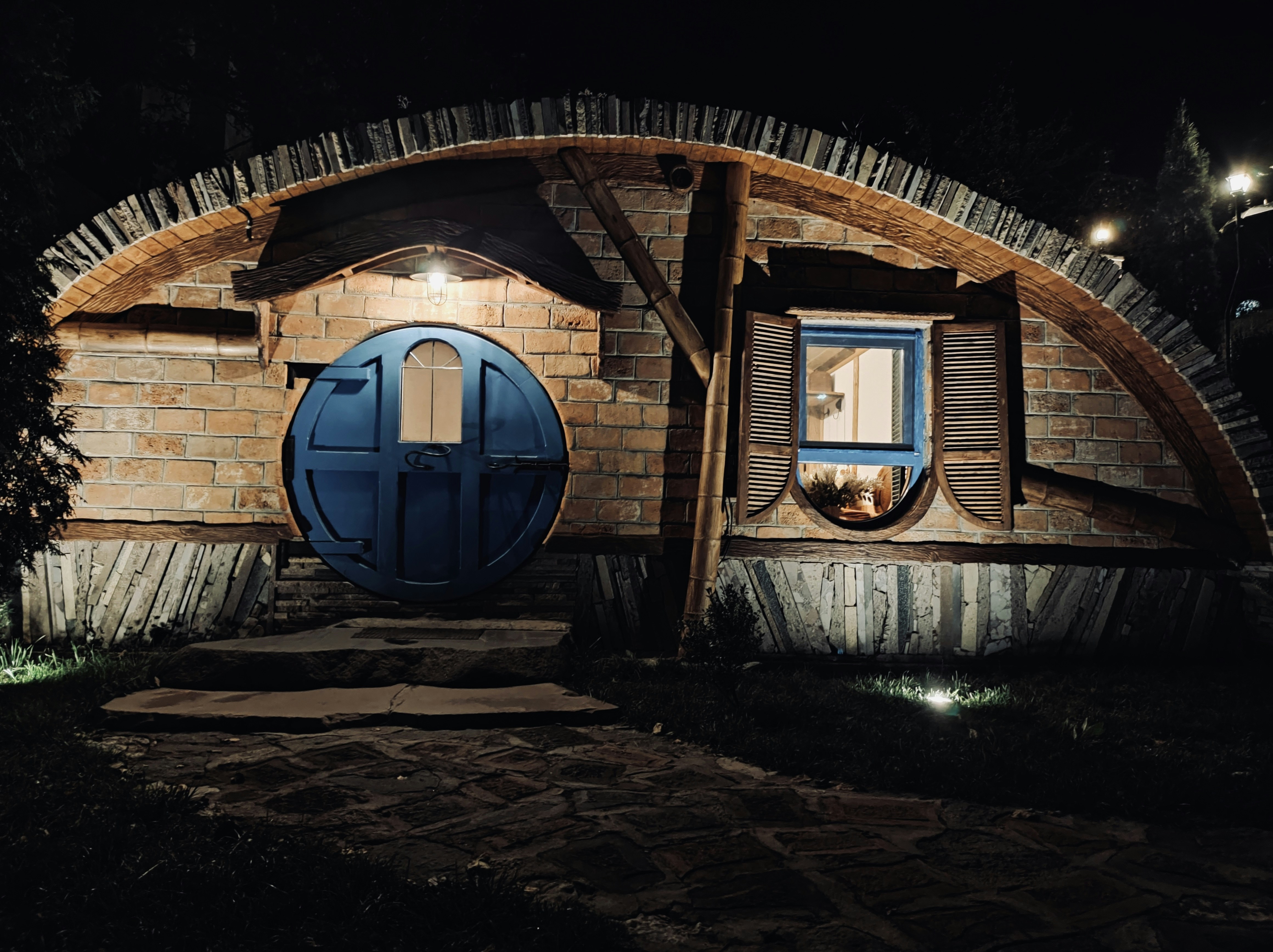 a hobbot house with a blue door at night