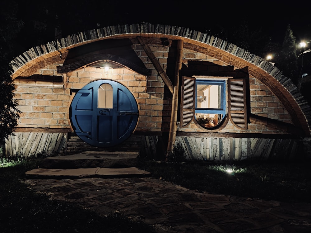 a hobbot house with a blue door at night