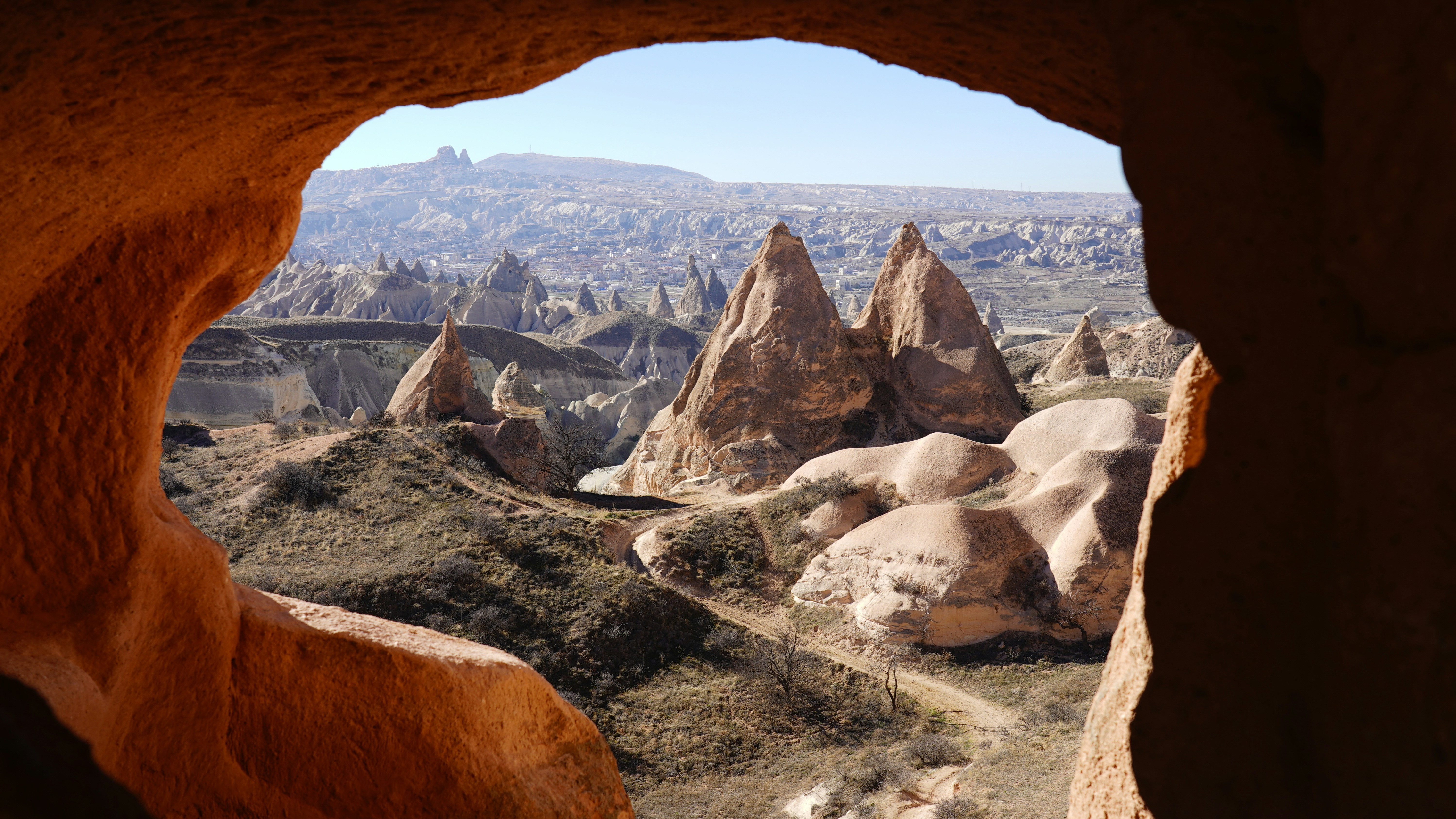 A hole in a rock formation with a view of a valley photo – Free Scenery ...