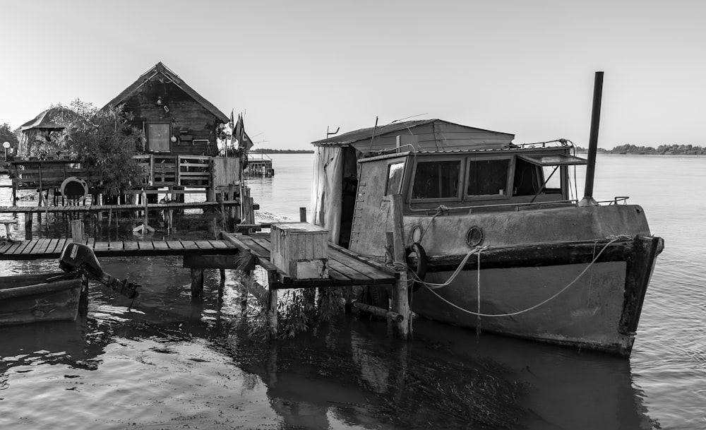 a black and white photo of a boat tied to a dock