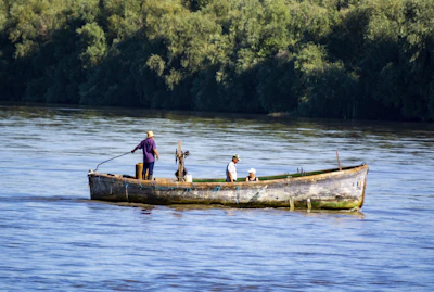 a man and two children in a boat on the water