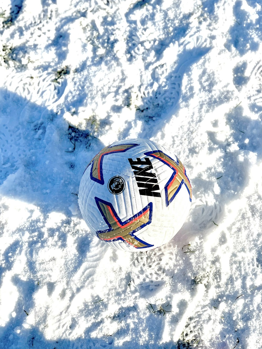 a soccer ball laying in the snow on the ground