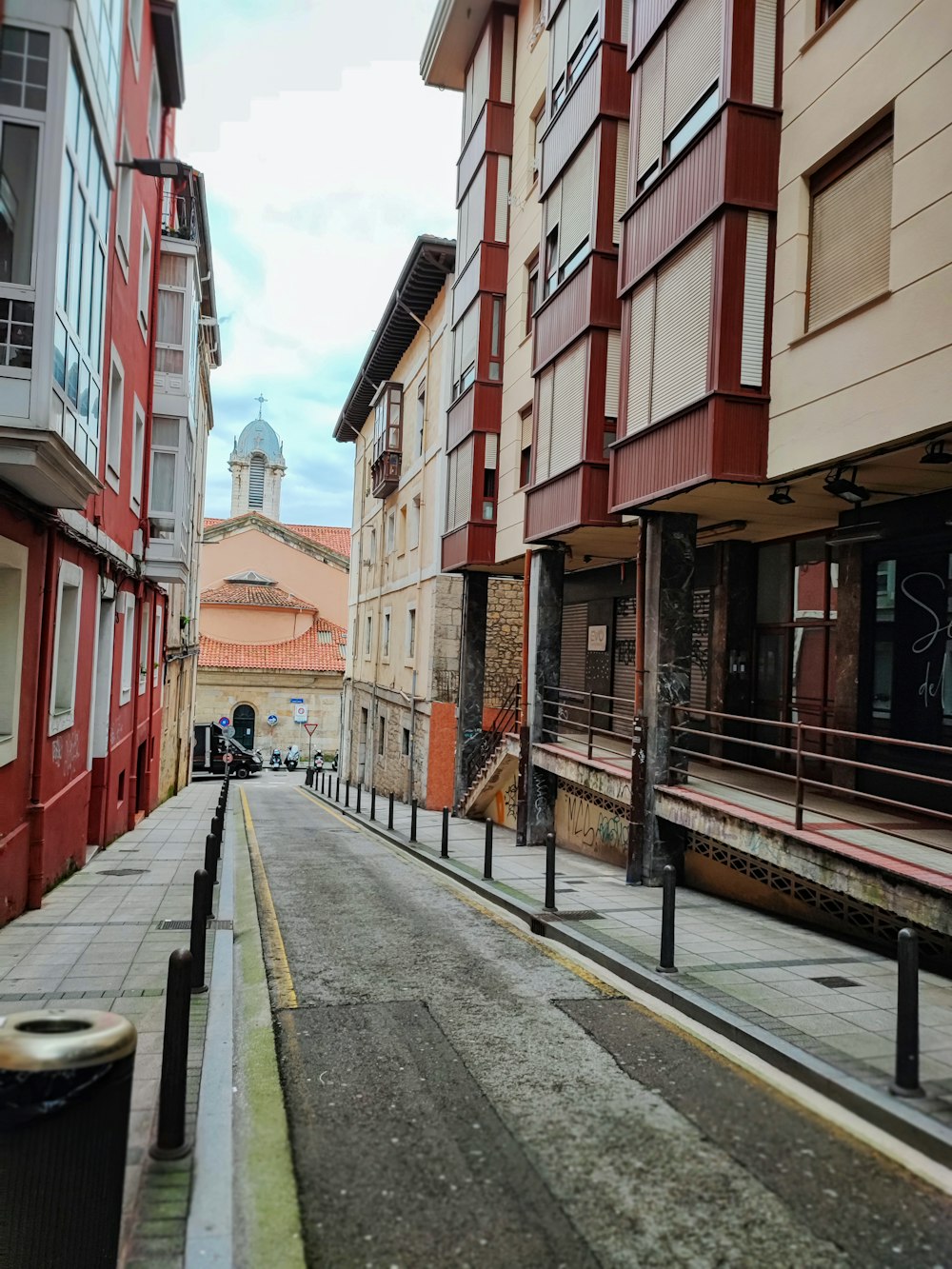 a city street with buildings and a clock tower in the background