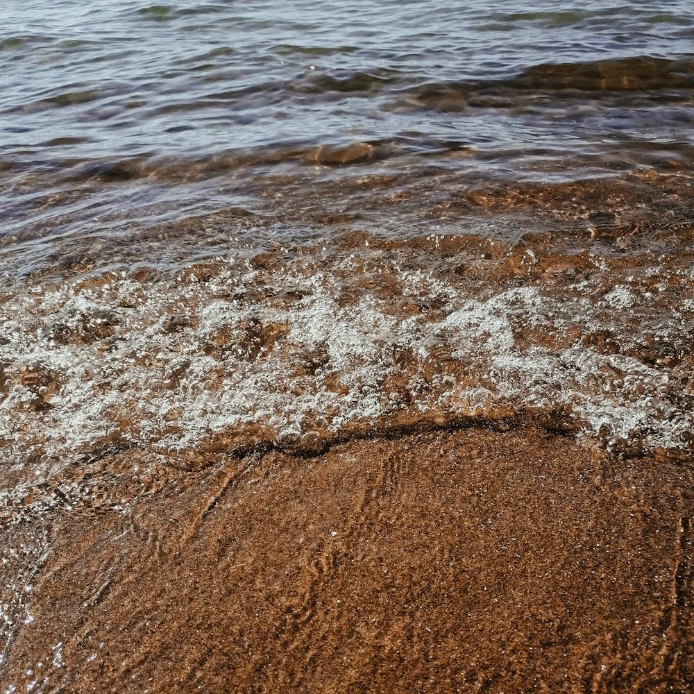 a close up of water and sand on a beach