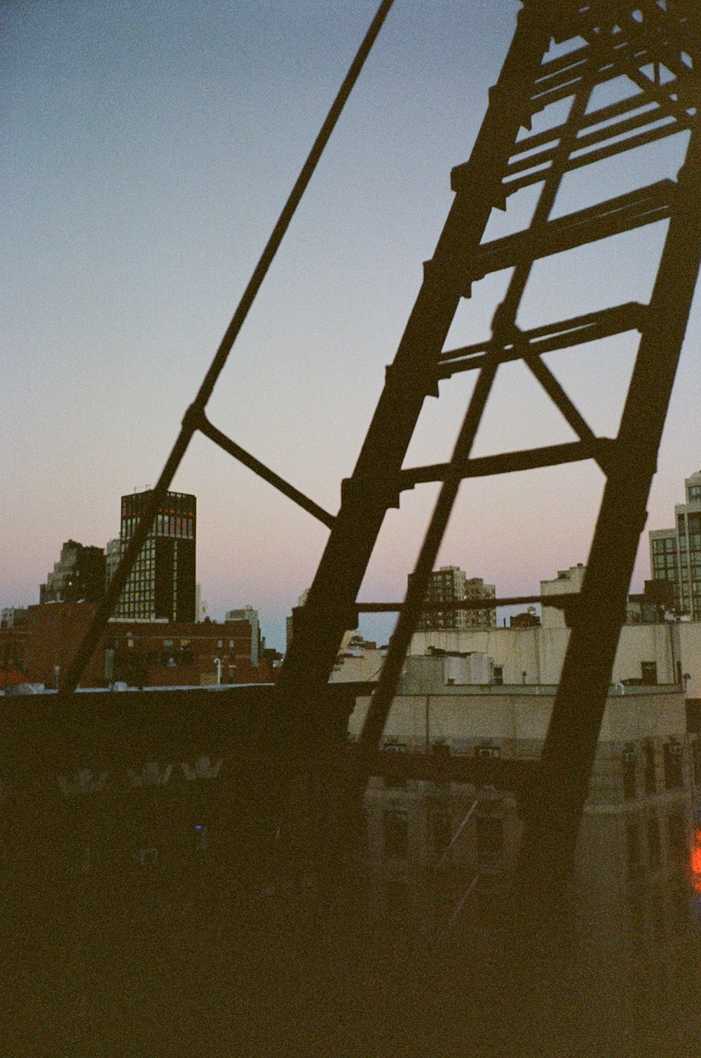 a tall metal structure with a city in the background