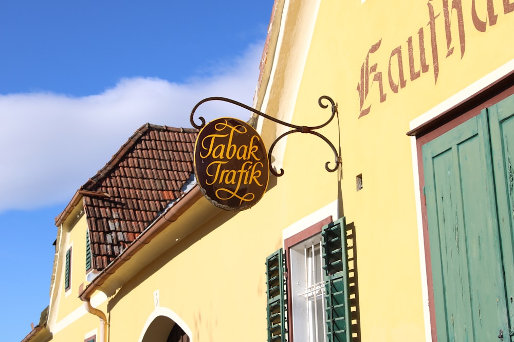 a sign on the side of a yellow building