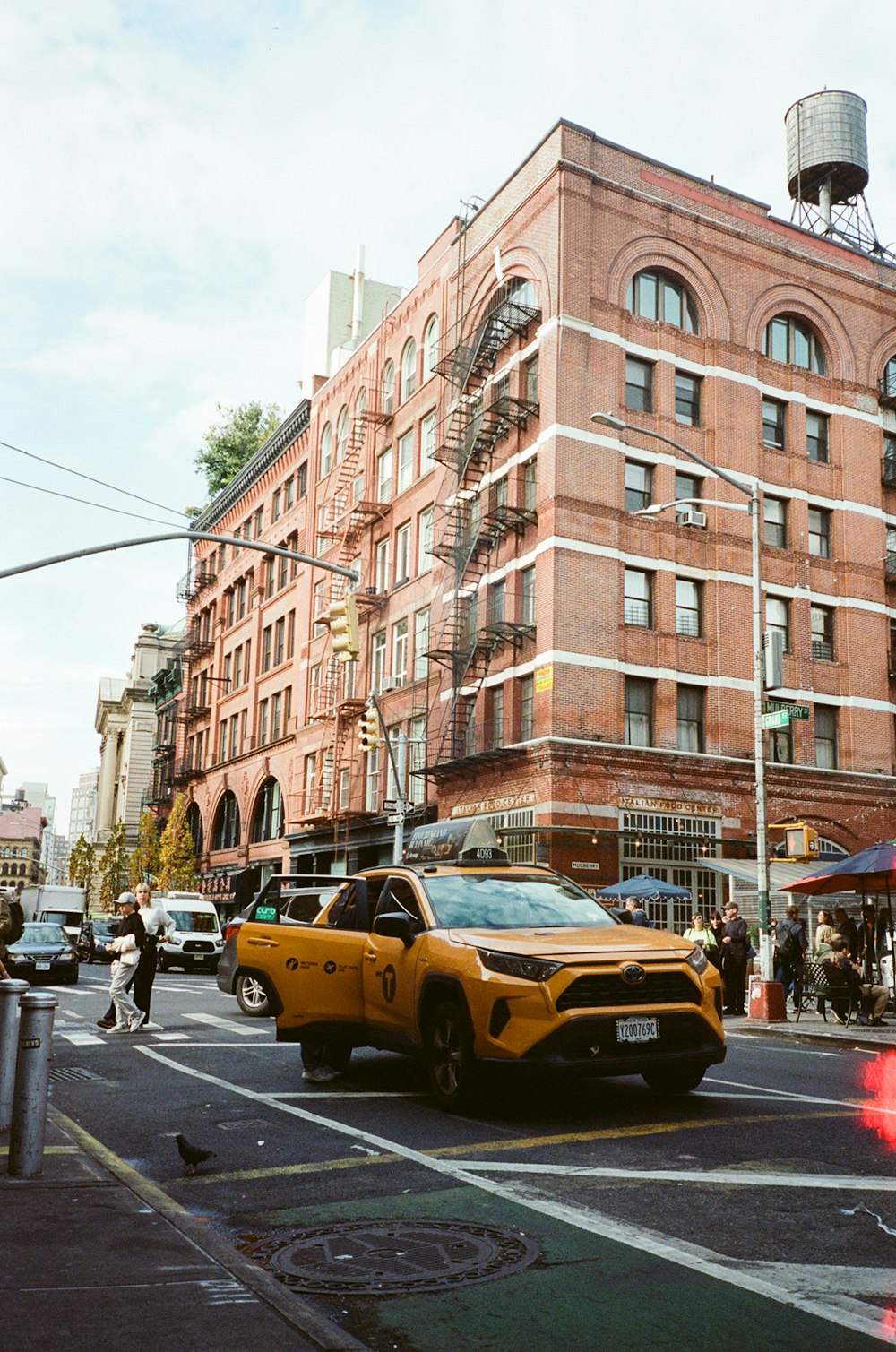 a yellow taxi cab driving down a street next to tall buildings