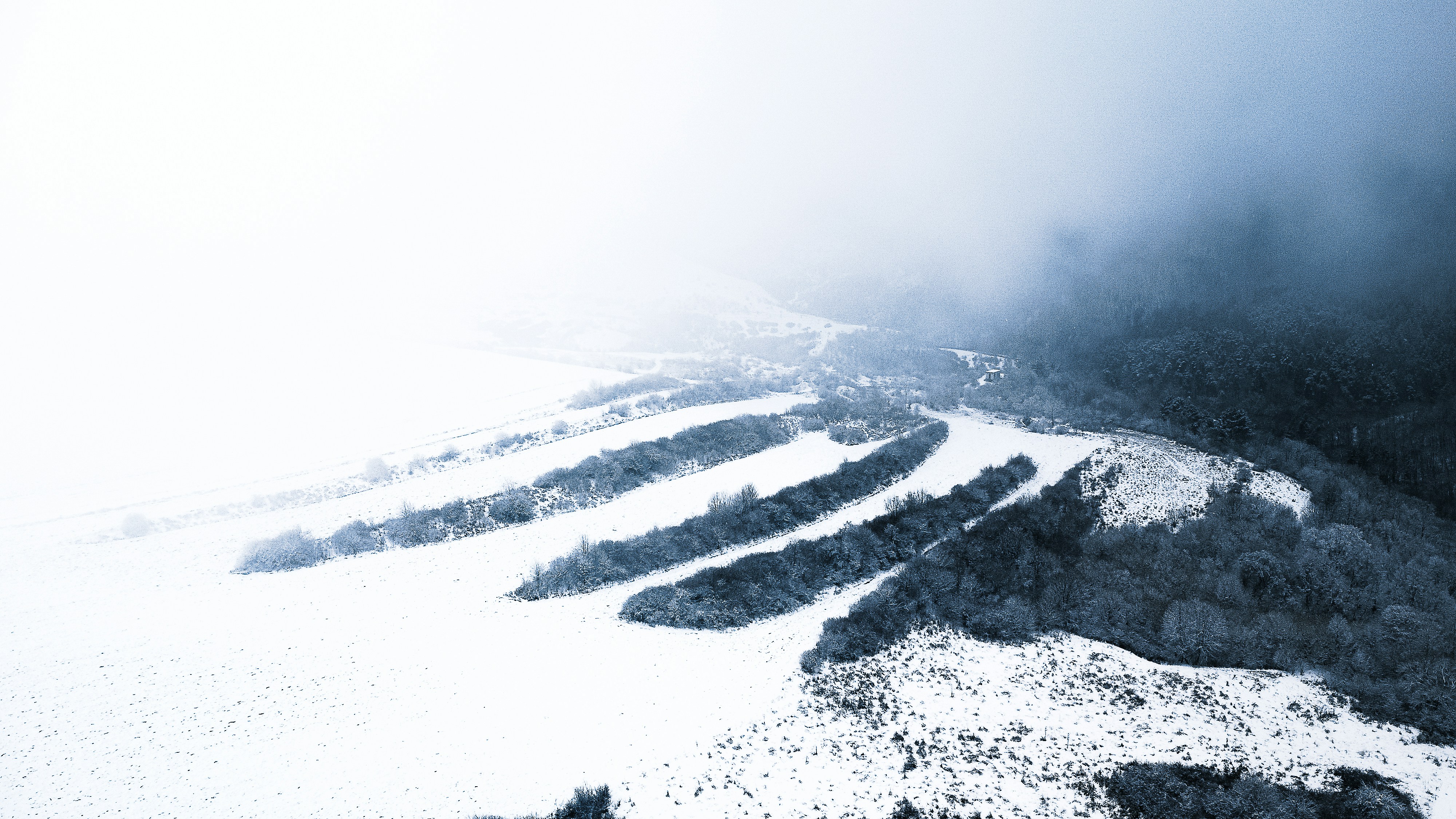 une montagne enneigée avec un snowboarder qui la descend
