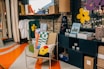 A cozy shop corner with colorful items and warm lighting, inviting customers to browse.