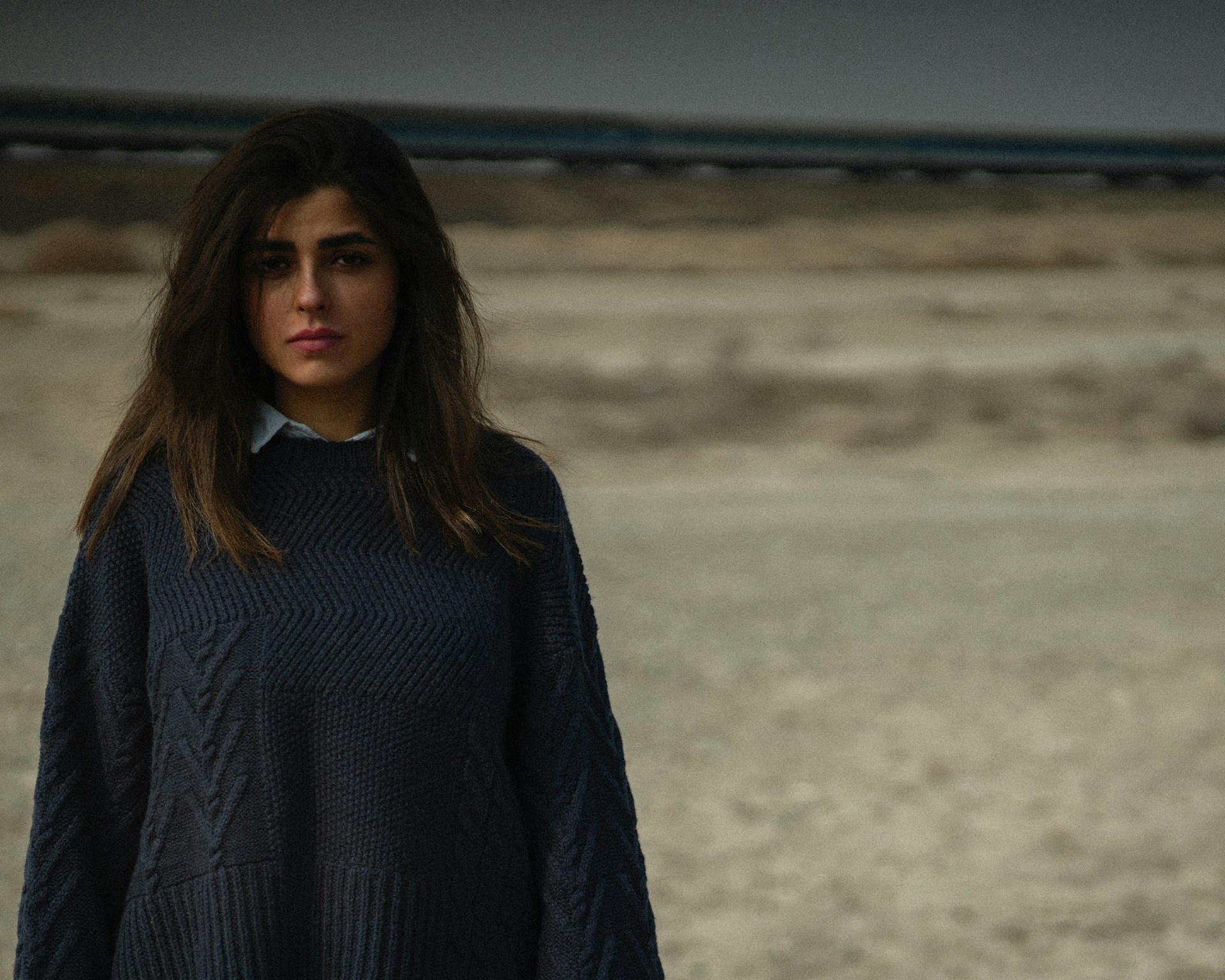a woman standing in the middle of a desert