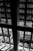 Black and white photo of a dusty cell window with sunlight streaming through bars.