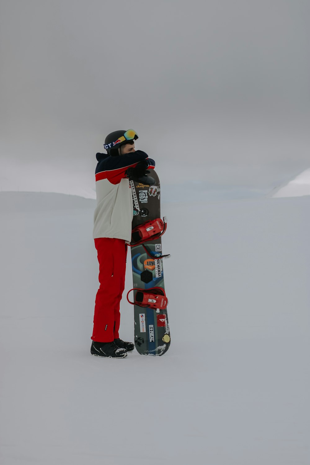 Una persona parada en la nieve con una tabla de snowboard