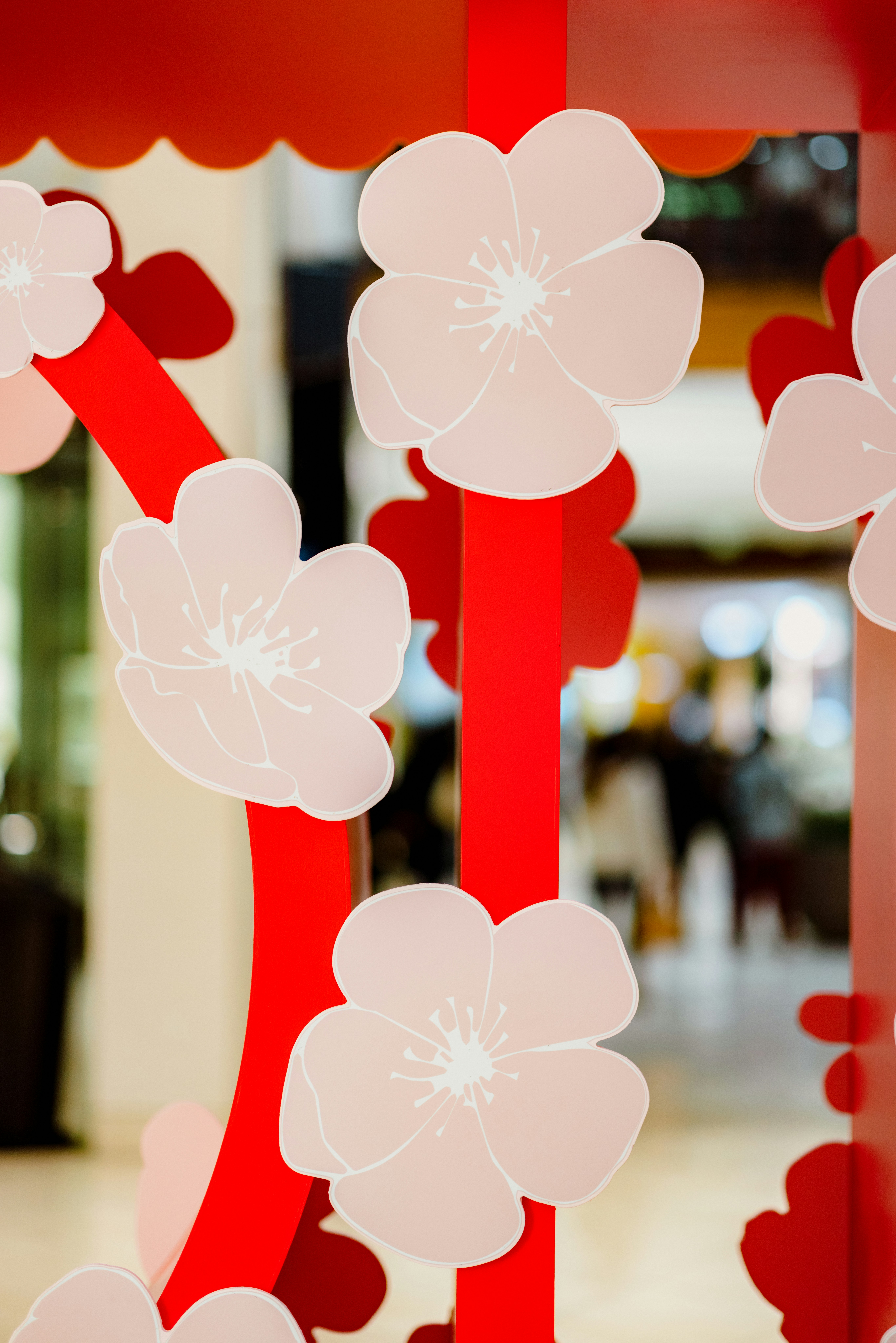 a group of red and white flowers hanging from a ceiling