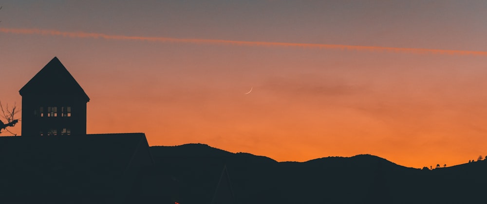 a building with a steeple and a cross in the sky