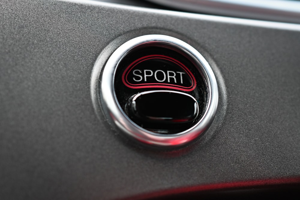 a close up of a sport button on a car