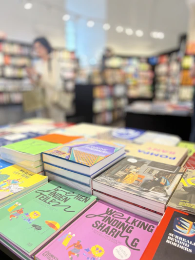 A vibrant stack of freshly published novels with colorful covers on a wooden table.