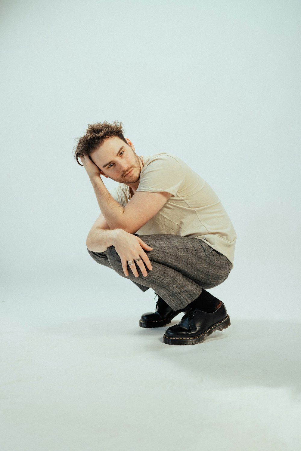 a man sitting on the ground with his hand on his head