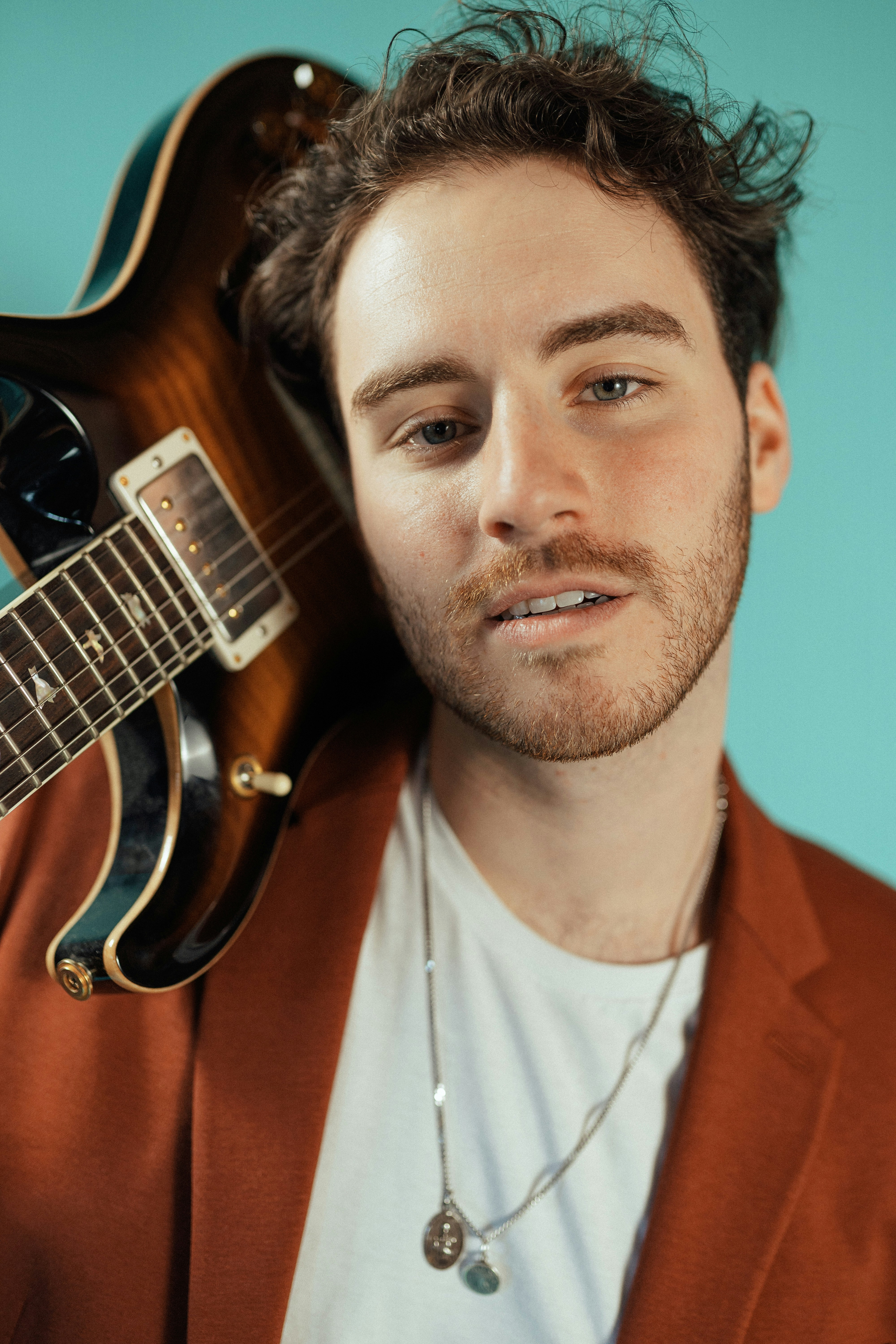 Ein Mann, der eine Gitarre vor sein Gesicht hält