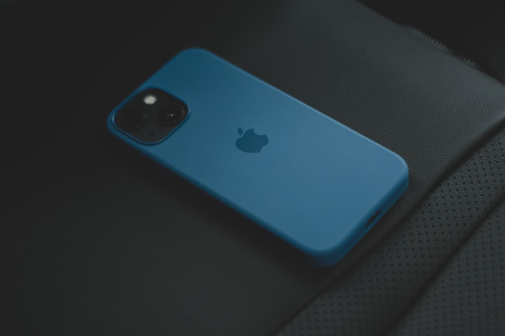 um iphone azul sentado em cima de um assento de carro