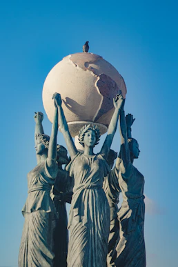 a statue of three women carrying a globe on their heads