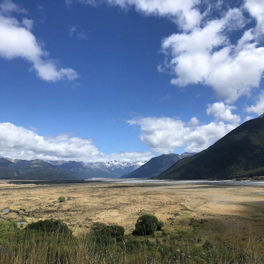 a large open field with mountains in the background