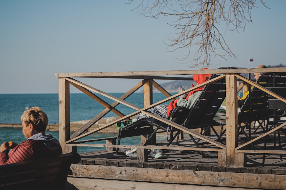 a woman sitting on a bench looking out at the ocean