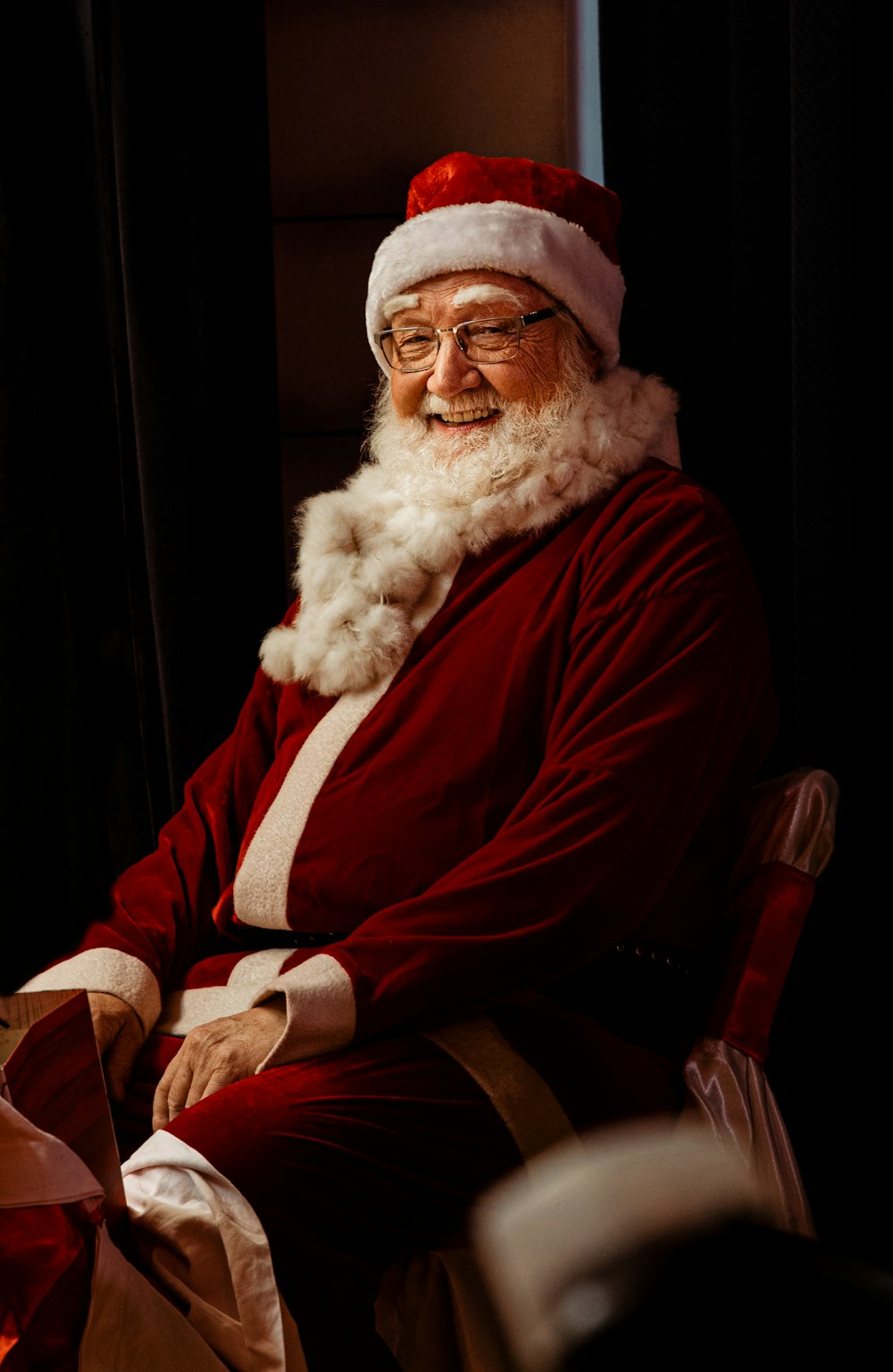 a man dressed as santa claus sitting in a chair