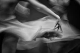 An artistic black and white photo capturing motion blur of dancers.