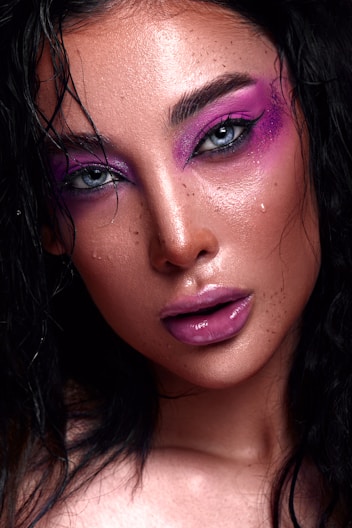 a close up of a woman with purple makeup