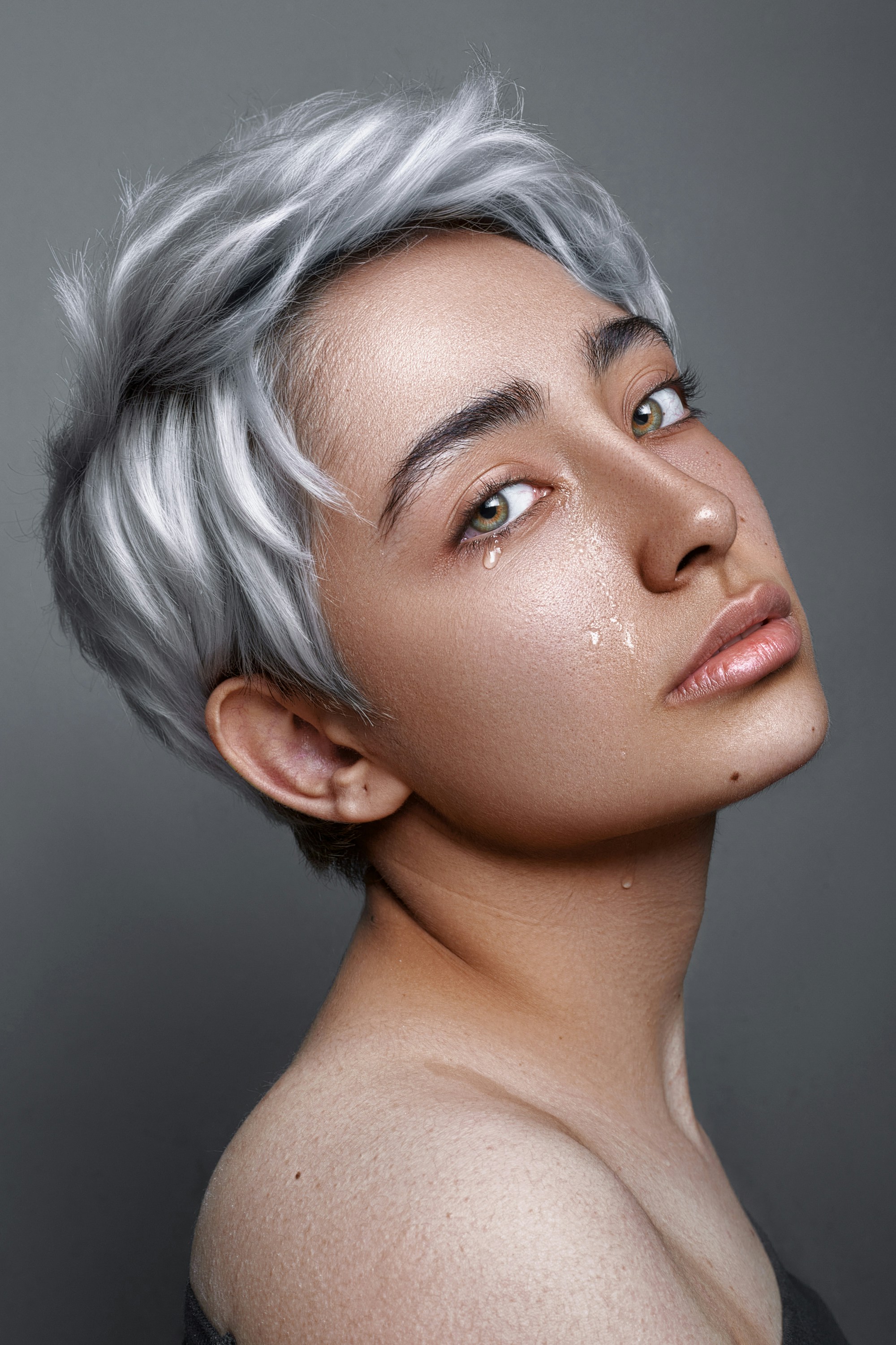 a non-binary pixie cut with short layers in silver color