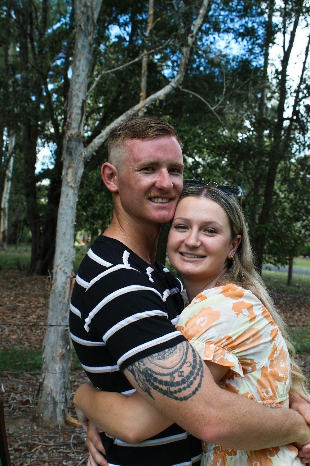 a man and a woman hugging in the woods