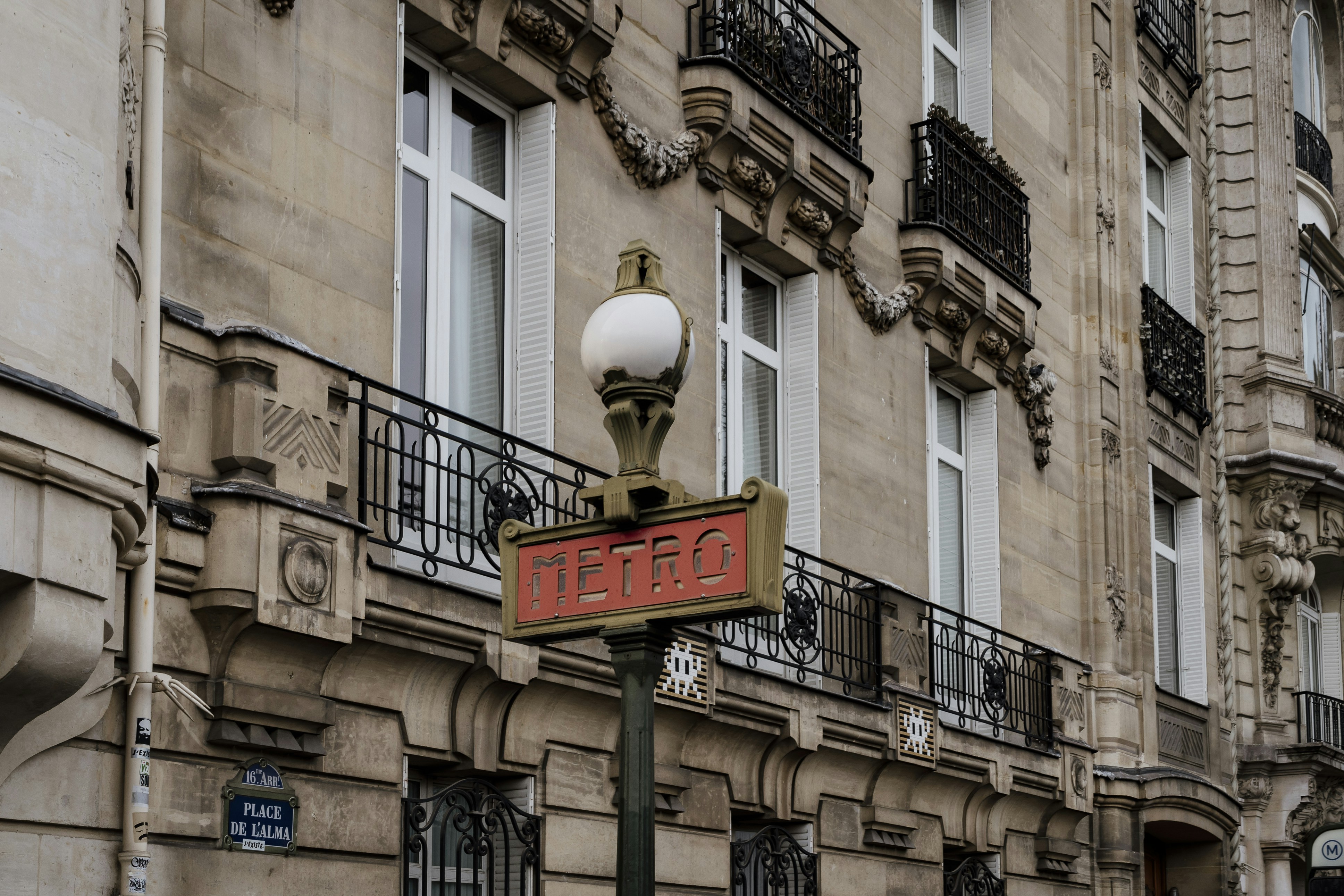 a street sign in front of a building, Old Paris metro sign