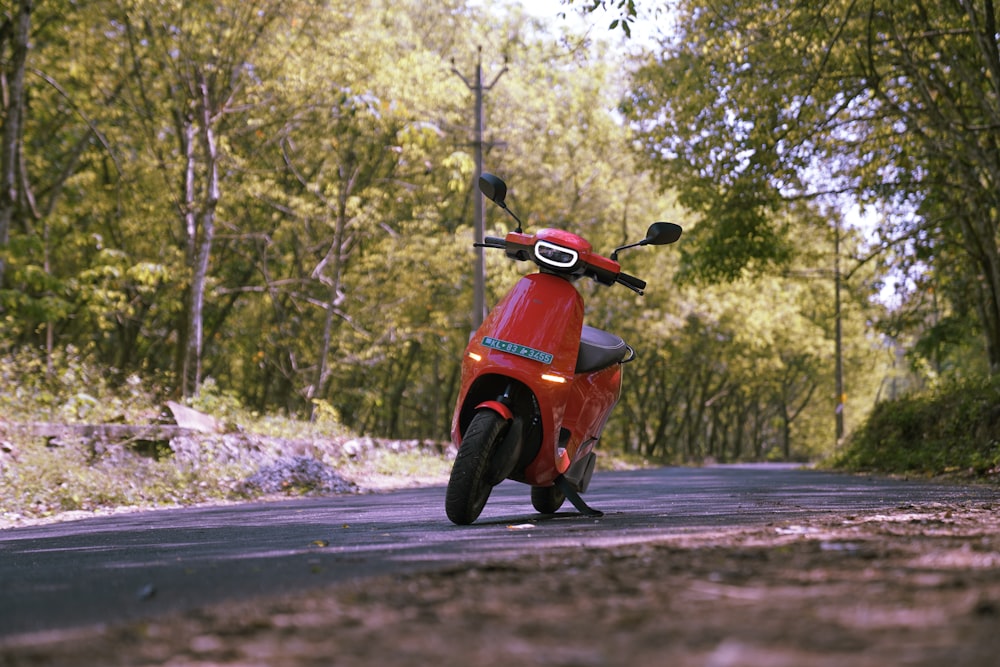 a red scooter parked on the side of a road