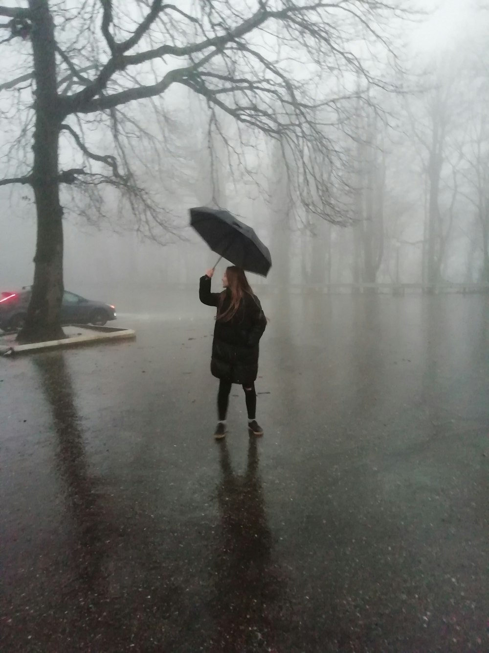 uma mulher que segura um guarda-chuva na chuva